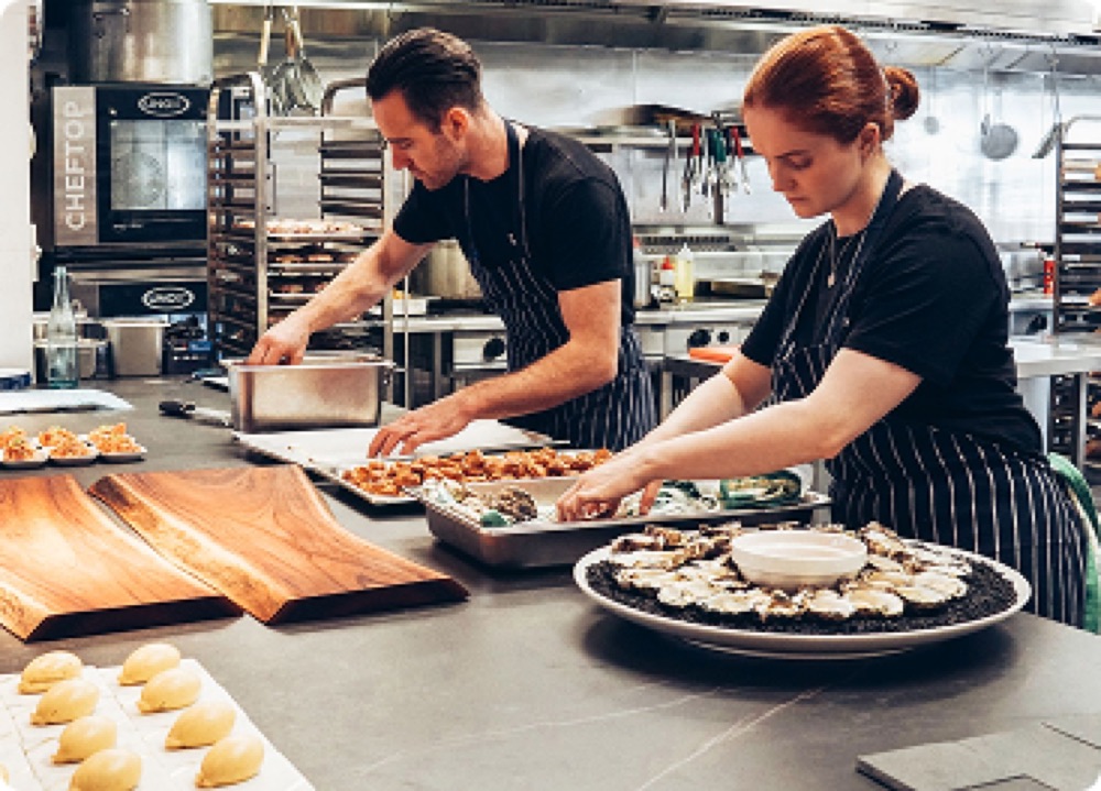 Chefs plating dishes in a restaurant kitchen
